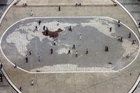Visitors walk by a world map carved in stone at a plaza in southwest China's Chongqing municipality on May 19, 2010.
