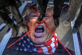 Protesters stand on an image depicting U.S. President Donald Trump during a gathering to protest the U.S. and Israeli war against Iran, seen in Ankara, Turkey, on March 1.